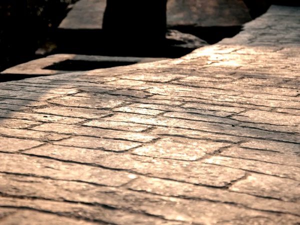 Stamped concrete with a stone pattern catching low evening light